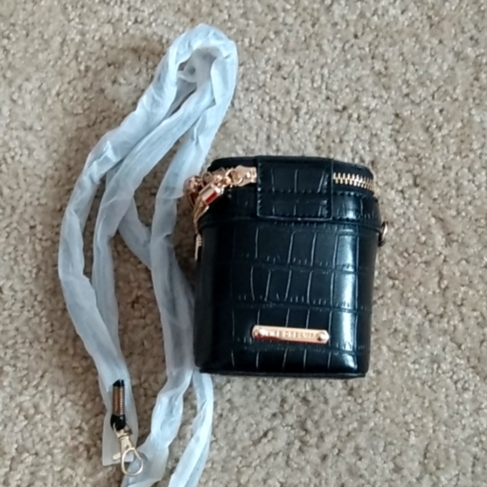 A black stand up gold purse with strap